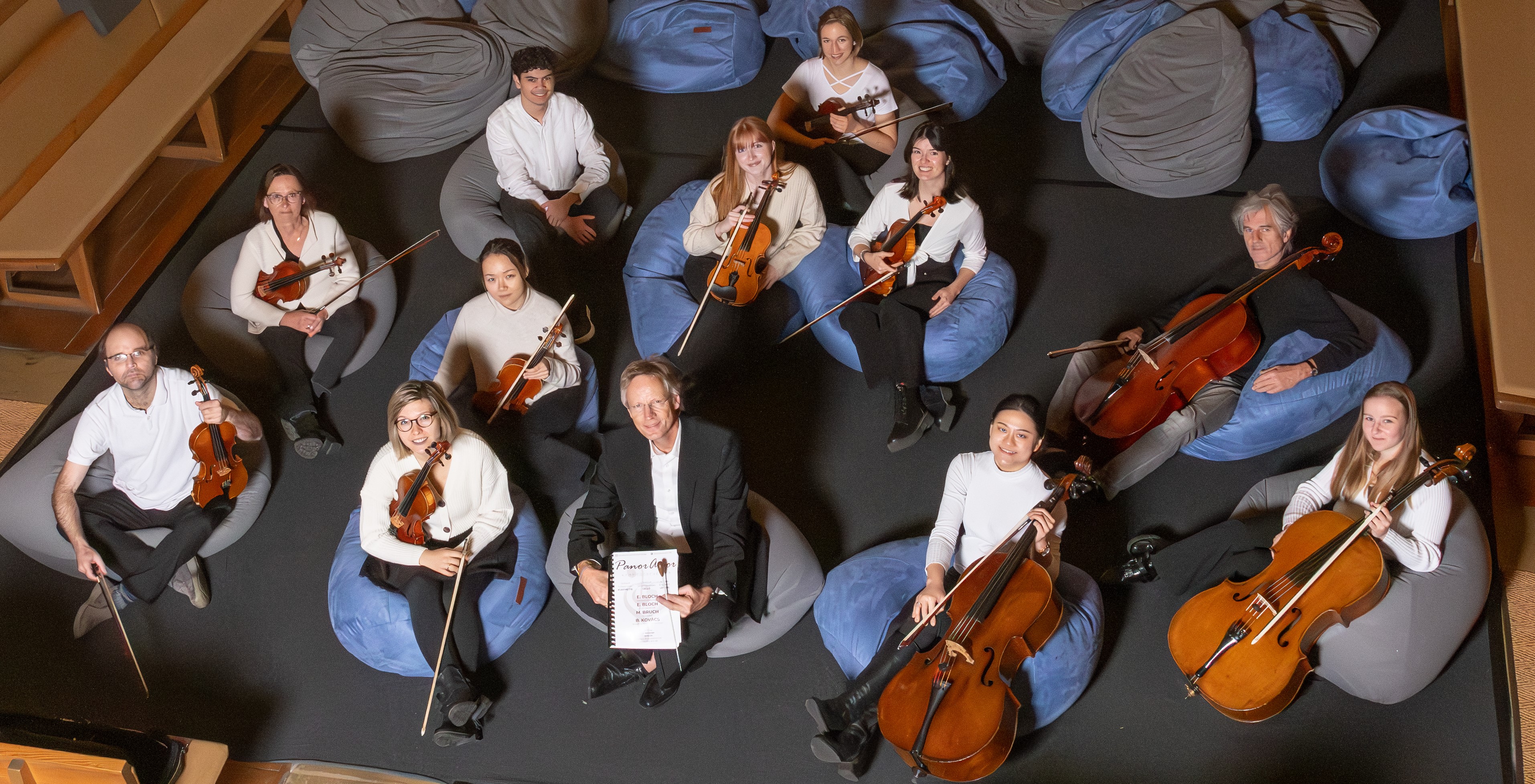 Ein Kammerorchester auf Sitzkissen aus der Vogelperspektive